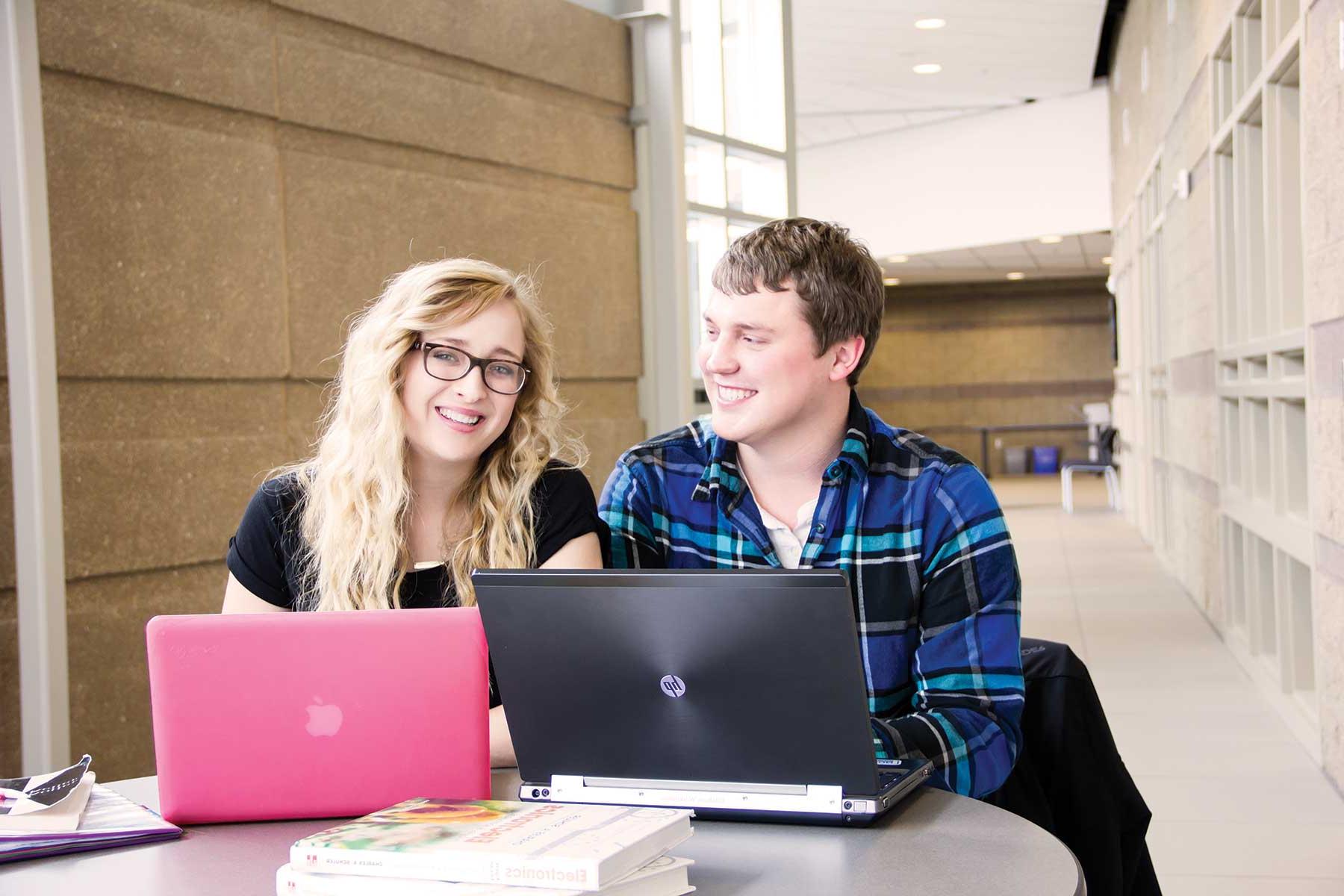 Two students with laptops